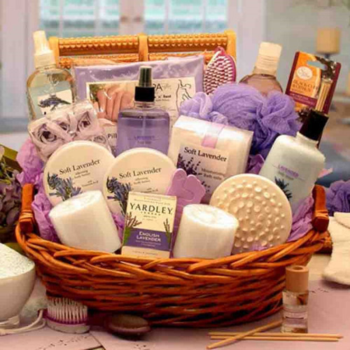 A home spa gift featuring calming Lavender products such as lavender lotion, body scrub, gel, salts, fizzies, body mist, body butter, soap, room spray, and diffuser topped off with a loofah, massagers, bath pillow, candles, and pedicure brush. Contents In #gift